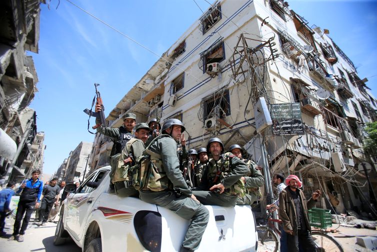 REUTERS/Ali Hashisho/Proibida reprodução Members of the Syrian police hold their weapons as they sit on a back of a truck at the city of Douma, Damascus, Syria April 16, 2018. REUTERS/Ali Hashisho