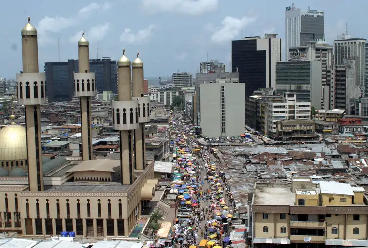 People and traffic move along a busy street in Lagos, Nigeria, May 24,2005. The African Union (AU) celebrates Africa Day on Wednesday May 25, marking the anniversary of the founding in 1963 of the Organization of African Unity, replaced in 2002 by the AU as the driving force behind the struggle for peace, democracy, development, human rights and good governance on the worlds poorest continent. REUTERS/George Esiri  FOR/LA