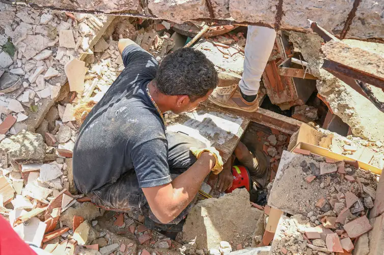 REUTERS/Maxwell Briceno/Proibida reprodução People work to rescue a man trapped under the rubble of a collapsed building, in the aftermath of earthquakes in La Guaira, Venezuela, June 25, 2026. REUTERS/Maxwell Briceno